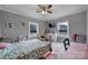 Cozy bedroom with neutral walls, windows, ceiling fan and colorful accents at 836 Love Rd, Blackstock, SC 29014