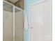 Bathroom shower with glass door and a white door with a towel hanging on it at 8513 Loxton Cir, Charlotte, NC 28214