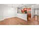 Open dining area with hardwood floors, elegant lighting, and a view into the adjacent kitchen at 8513 Loxton Cir, Charlotte, NC 28214