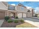 Traditional townhouse with a brick facade and manicured landscaping and a three-car garage at 8513 Loxton Cir, Charlotte, NC 28214