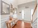 Bright foyer with wainscoting, decorative mirrors and an entry table next to the front door at 8513 Loxton Cir, Charlotte, NC 28214