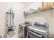 Functional laundry room featuring modern washer, dryer, and shelving at 8513 Loxton Cir, Charlotte, NC 28214