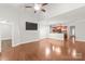 Open-concept living area showcasing hardwood floors, a ceiling fan, and a seamless flow to the kitchen at 8513 Loxton Cir, Charlotte, NC 28214