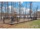 Community playground with slides, climbing structures, and swings surrounded by a black fence and trees at 8513 Loxton Cir, Charlotte, NC 28214