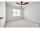 Bright bedroom with a ceiling fan, neutral carpet, and a window providing natural light at 8929 Bryant Field Cir, Charlotte, NC 28277