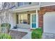 Inviting front entrance with a blue door, landscaped shrubbery, and one car garage at 8929 Bryant Field Cir, Charlotte, NC 28277
