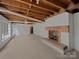 Unfinished basement with a brick fireplace, concrete floors, and exposed wood beams at 924 Springdale Ln, Gastonia, NC 28052