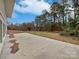 Concrete patio area with a view of the expansive, tree-lined backyard at 924 Springdale Ln, Gastonia, NC 28052