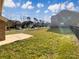 View of a spacious backyard with healthy grass, bordered by a black fence and neighboring houses under a partly cloudy sky at 9503 Rocky Spring Nw Ct, Concord, NC 28027