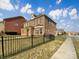 Two-story brick home showcasing architectural details, a black fence, and a well-manicured lawn on a sunny day at 9503 Rocky Spring Nw Ct, Concord, NC 28027