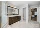 Bright bathroom featuring a white tiled floor, a glass shower, and a double vanity at 10207 Rattersly Ct, Charlotte, NC 28277