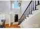 Elegant foyer showcasing a staircase with a black railing and hardwood floors, and a modern chandelier at 10207 Rattersly Ct, Charlotte, NC 28277