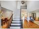 Elegant foyer showcasing a staircase with a black railing and hardwood floors, and a modern chandelier at 10207 Rattersly Ct, Charlotte, NC 28277