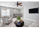 Cozy living room featuring carpet, a ceiling fan, a wall-mounted television, and neutral decor at 10207 Rattersly Ct, Charlotte, NC 28277