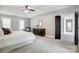 Bright main bedroom featuring a tray ceiling, ceiling fan, and a dark dresser at 10207 Rattersly Ct, Charlotte, NC 28277