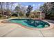 Inviting in-ground pool with a spacious concrete deck, a gazebo, and mature trees at 10207 Rattersly Ct, Charlotte, NC 28277