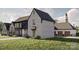 A stone and black-trimmed home with a porte-cochere and 3-car garage nestled in a serene, green landscape at 1057 Maxwell Ct # 13, Marvin, NC 28173