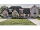A stunning view of a stone-clad house with a porte-cochere and well-manicured lawn showcasing architectural design at 1057 Maxwell Ct # 13, Marvin, NC 28173