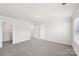 Carpeted bedroom with neutral walls and trim, multiple doors, and bright natural light through a window at 114 Ciara Pl # C, Mooresville, NC 28117