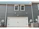 Two-car garage door of the townhouse with gray siding and white trim, under a blue sky at 114 Ciara Pl # E, Mooresville, NC 28117