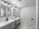Bright bathroom with double vanity, modern fixtures, and marble-look tile at 118 W Lee Ave, Bessemer City, NC 28016
