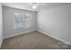 Bright bedroom featuring neutral carpet, white walls, and a large window with blinds at 118 W Lee Ave, Bessemer City, NC 28016
