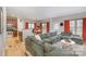 Spacious living room with a large green sectional sofa, wood floors, and bright lighting at 121 Inlet Point Dr, Tega Cay, SC 29708