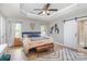 Serene main bedroom with tray ceiling, wood floors, and sliding barn door to en-suite at 121 Inlet Point Dr, Tega Cay, SC 29708