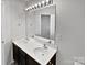 Bathroom featuring a dual sink vanity, large mirror with decorative lighting at 121 Woodbridge Cir, Mount Holly, NC 28120