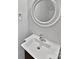 Bathroom featuring a white sink, faucet, and a round mirror at 121 Woodbridge Cir, Mount Holly, NC 28120