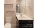 Well-lit half bathroom with a vanity, mirror, and floating shelves at 13217 Reunion St, Charlotte, NC 28278