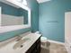 Blue bathroom featuring a large mirror, a vanity with ample counter space, and a toilet at 13217 Reunion St, Charlotte, NC 28278