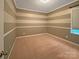 Cozy bedroom with horizontal striped walls, plush carpeting, and a window providing natural light at 13217 Reunion St, Charlotte, NC 28278