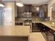 Well-equipped kitchen featuring dark wood cabinetry, granite countertops, stainless steel appliances, and a spacious island at 13217 Reunion St, Charlotte, NC 28278