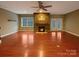 Bright living room featuring a stone fireplace, ceiling fan, and hardwood floors at 13217 Reunion St, Charlotte, NC 28278