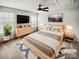 Relaxing bedroom with neutral tones, large windows, ceiling fan and sleek wood furniture at 144 Tetcott St, Mooresville, NC 28115