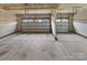 A large, unfinished two-car garage with concrete floors and white garage doors at 144 Tetcott St, Mooresville, NC 28115