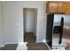View of the entryway and front door, adjacent to the kitchen and stainless steel refrigerator at 15200 Chowning Tavern Ln, Charlotte, NC 28262