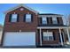 Two-story brick home with a two-car garage and black trimmed windows at 15200 Chowning Tavern Ln, Charlotte, NC 28262