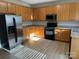 Well-lit kitchen featuring stainless steel appliances and ample wooden cabinet space at 15200 Chowning Tavern Ln, Charlotte, NC 28262