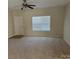 Bright living room with neutral paint, ceiling fan, and carpeted floors at 15200 Chowning Tavern Ln, Charlotte, NC 28262