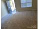 Open living room with carpeted floors and a window at 15200 Chowning Tavern Ln, Charlotte, NC 28262