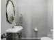 Powder room features pedestal sink, oval mirror and nearby toilet at 16110 Foreleigh Rd, Huntersville, NC 28078