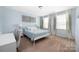 Bright bedroom featuring large windows, a metal bed frame, and neutral walls at 16110 Foreleigh Rd, Huntersville, NC 28078