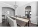 Open dining room with a chandelier, a long table and access to kitchen at 16110 Foreleigh Rd, Huntersville, NC 28078