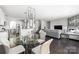 Open-concept living space with a modern chandelier over a glass table and a comfortable gray sofa at 16110 Foreleigh Rd, Huntersville, NC 28078