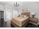 Bedroom with a rustic wooden bed, neutral decor, and access to the bathroom and closet at 16110 Foreleigh Rd, Huntersville, NC 28078