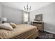 Bedroom with a rustic wooden bed, neutral decor, a chandelier, and a dresser with round mirror at 16110 Foreleigh Rd, Huntersville, NC 28078