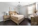 Bedroom with a rustic wooden bed, neutral decor, and ample natural light at 16110 Foreleigh Rd, Huntersville, NC 28078