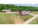 Expansive aerial view of red farmhouse, barns, and lush greenery at 223 Scottish Dr, Mooresville, NC 28115